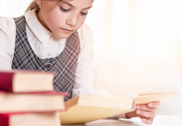 schoolgirl reading a book close-up in the library