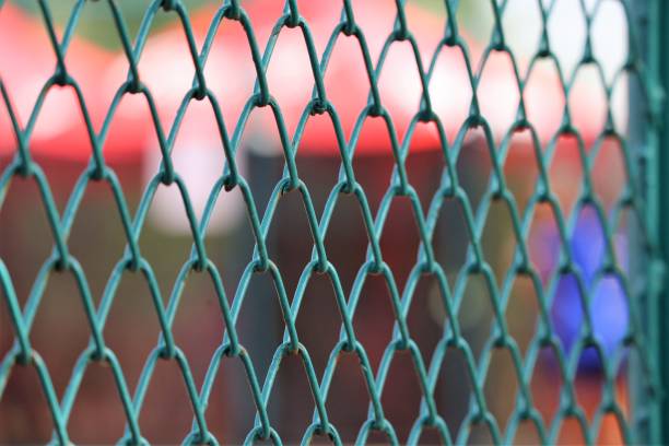 grüner drahtgeflechtstahl auf dem tennisplatz - green fence chainlink fence wall stock-fotos und bilder