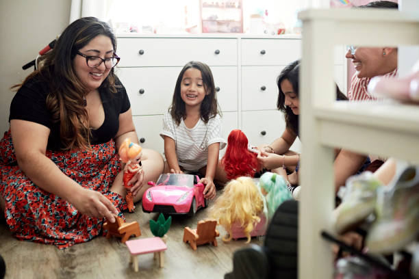 genitori lesbiche e giovani figlie che giocano con le bambole - bedroom accessories foto e immagini stock