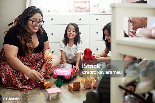 istock Lesbian parents and young daughters playing with dolls 1411368454