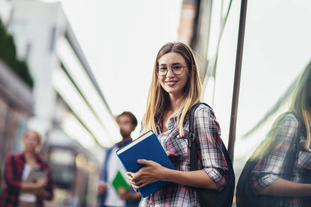 istock Happy university student going on a class at the university and looking at camera. 1411369571