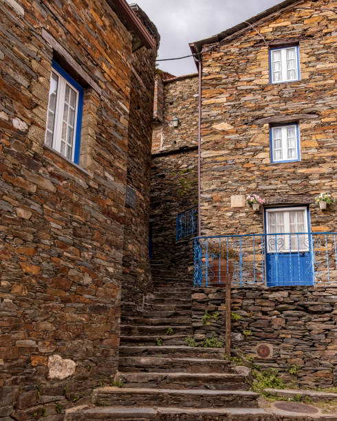 Old slate stone buildings with blue windows and doors. Stone stairs between the buildings. Piodao. Portugal