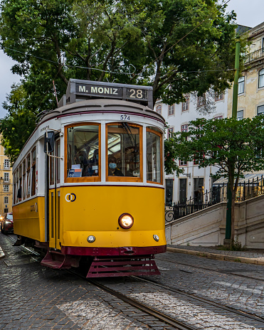 Yellow tram no. 28 on one of Lisbon's stone streets. Portugal