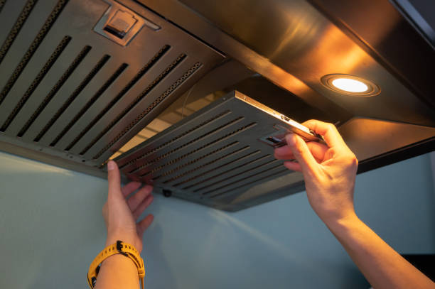 Woman hands trying to removing a filters from cooker hood for cleaning it. Clean your filters every two to three months, depending on your cooking habits. kitchen hood stock pictures, royalty-free photos & images