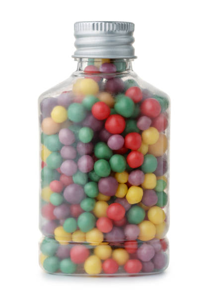 Close-Up Of Wrapped Chocolates In Jar Against White Background