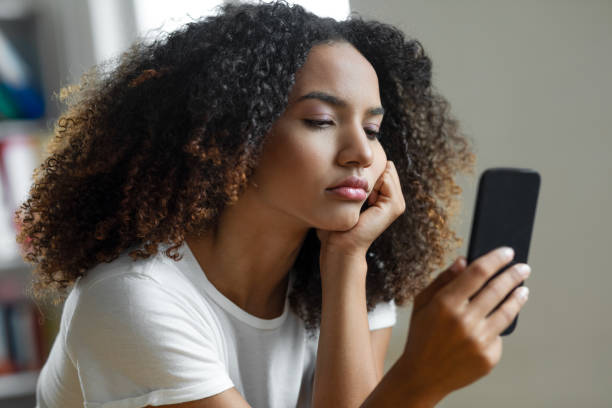 woman looking at mobile phone screen - frustration emotional stress surprise women imagens e fotografias de stock