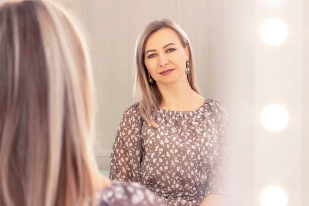 istock woman aged looks in the mirror. reflection in the mirror. elderly age 1411374749