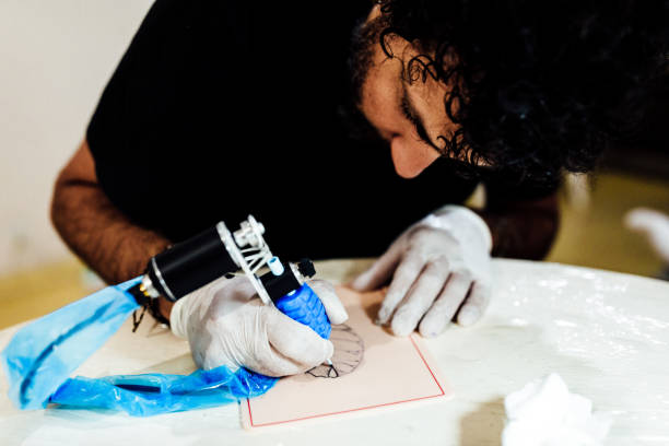 istock Man practicing tattoo on fake skin 1411375126