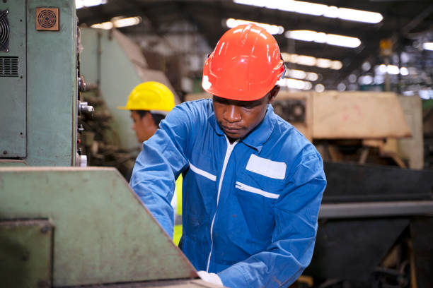 istock Blue collar worker works with machine at factory. 1411375753