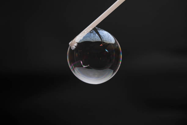 istock Beautiful soap bubbles are blown with a straw on a black background. Abstract soap bubbles with colorful reflections. 1411376131