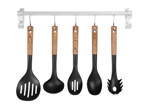 Metal rack with set of kitchen utensils on white background
