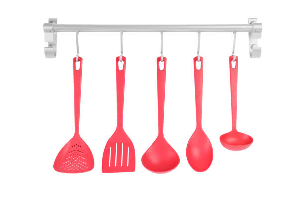 istock Metal rack with set of red kitchen utensils on white background 1411382556