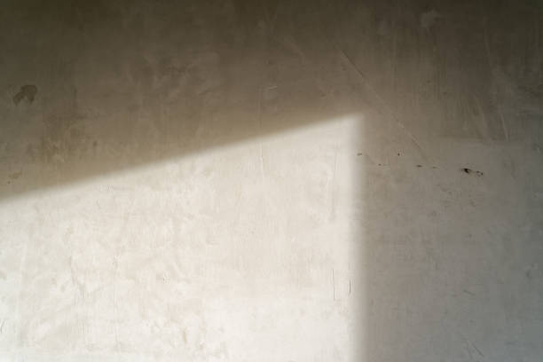 istock The light from the window hits the concrete wall inside the room without renovation. Concept of an apartment without finishing works, preparation for renovation. 1411383869
