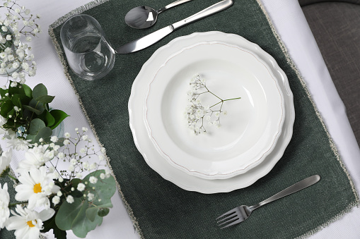 Elegant festive setting with floral decor on table, flat lay