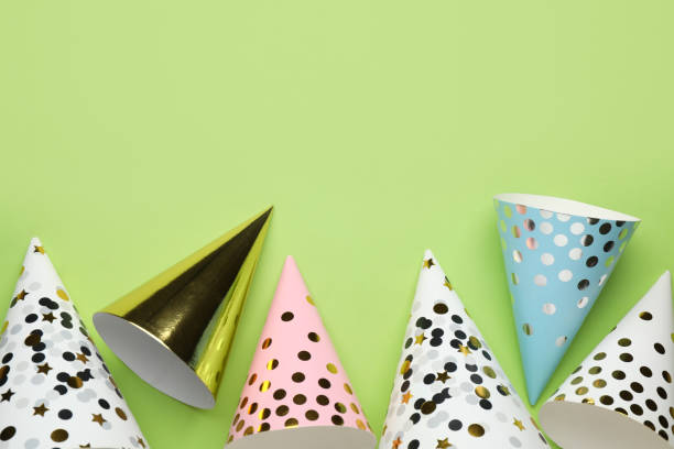 istock Bright party hats on light green background, flat lay. Space for text 1411386570