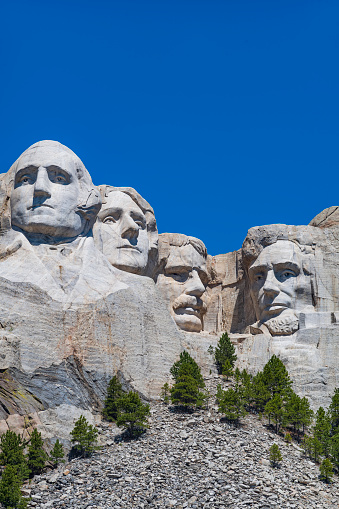 Detail of Mount Rushmore under a blue sky.