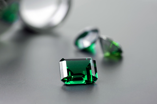 raw emeralds, gemstone jewelry on black background