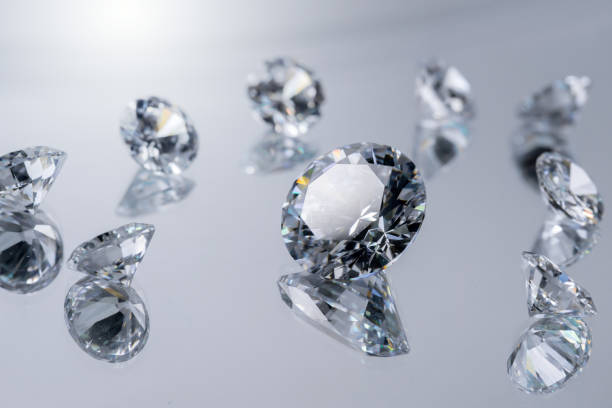 brilliant cut diamond held by tweezers on white background - diamond shaped fotos imagens e fotografias de stock