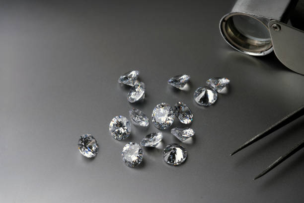 istock brilliant cut diamond held by tweezers on black background 1411397957