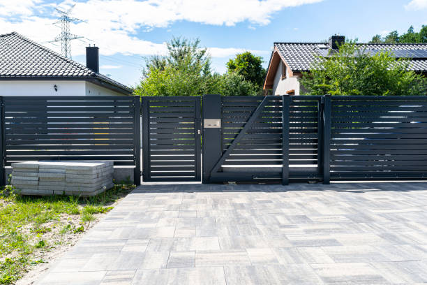 istock A modern panel fence in anthracite color, a visible sliding gate to the garage and a wicket with a letterbox. 1411398158