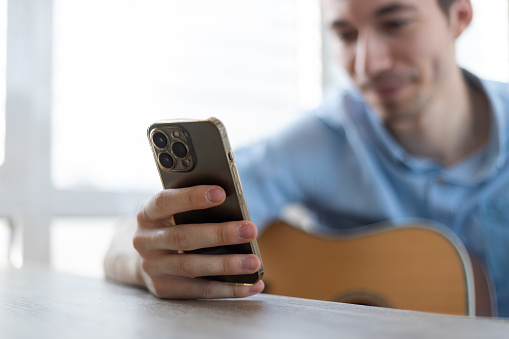 Man with a finger on the screen using a mobile phone in the office