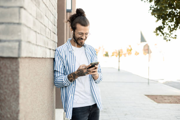 istock Young man enjoying music while waiting on the street 1411399763