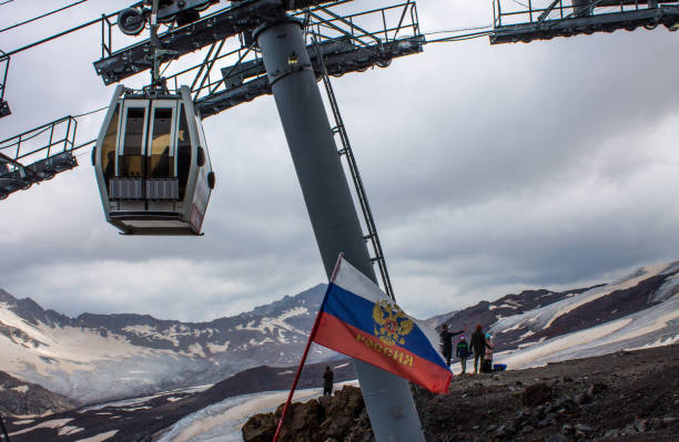 teleférico con cabinas que suben y bajan en lo alto de las montañas del cáucaso - overhead cable car summer ski lift scenics fotografías e imágenes de stock