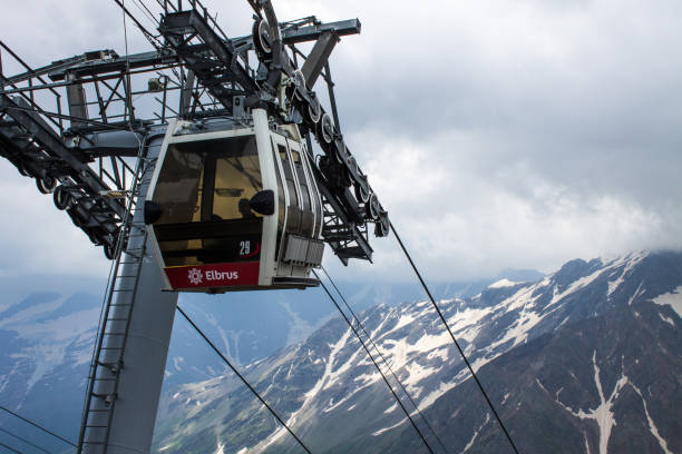 teleférico con cabinas que suben y bajan en lo alto de las montañas del cáucaso - overhead cable car summer ski lift scenics fotografías e imágenes de stock
