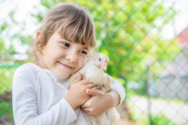 istock Cute Girl Embracing Hen 1411402171