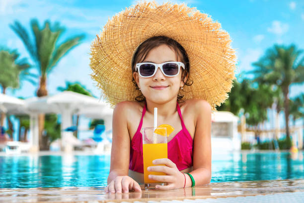 istock Smiling Girl With Orange Glass At Poolside 1411402867