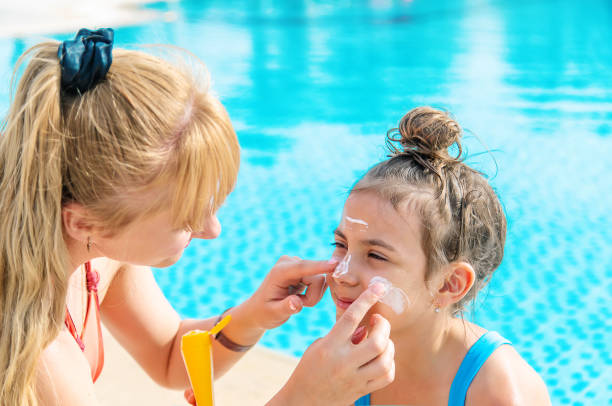 istock Mother Applying Suntan Lotion On Daughters Face 1411403584