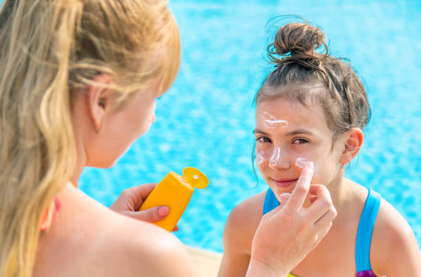 istock Mother Applying Suntan Lotion On Daughters Face 1411403595