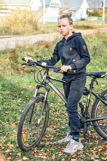 istock Blond schoolboy enjoys riding bicycle in countryside 1411405380
