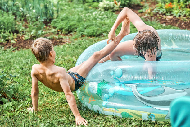 istock Brothers wrestle in childrens inflatable pool in yard 1411406605