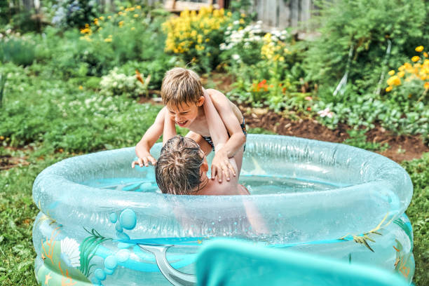 istock Brothers wrestle in childrens inflatable pool in yard 1411407497