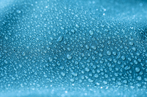 Water drops on blue background. Drops of water on surface. Macro photo. Splash pattern. Close-up.