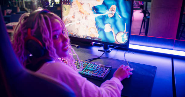 Pro gamer African ethnicity girl competing in video game eSport championship with a girl spectator stock photo