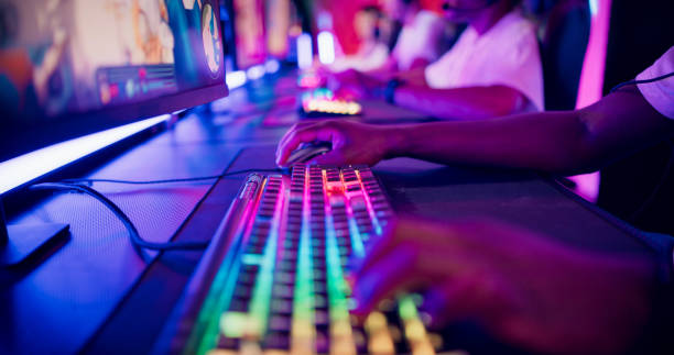 Close-up hand on a computer keyboard. Diverse pro gamer team with african ethnicity leader competing at video game eSport championship Diverse gamer group with african ethnicity players playing competitive MOBA PvP top down view computer game on a stage. Close-up on the hands esports stock pictures, royalty-free photos & images