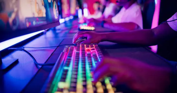 Photo of Close-up hand on a computer keyboard. Diverse pro gamer team with african ethnicity leader competing at video game eSport championship