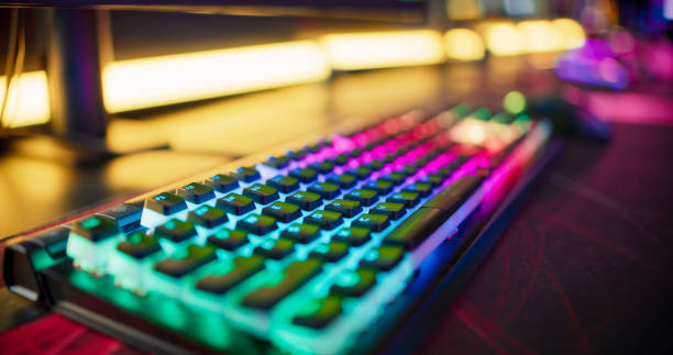 pro gamer team computer setup at video game esport championship with neon keyboard. video game on monitor screen - computer keyboard audio imagens e fotografias de stock