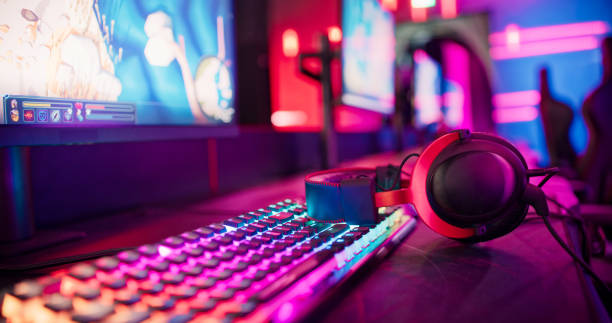 Pro gamer team computer setup at video game eSport championship with neon keyboard. Video game on monitor screen stock photo