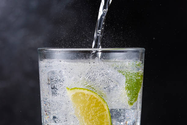 Gin and tonic Gin and tonic with ice and lime on dark background tonic water stock pictures, royalty-free photos & images