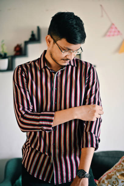 istock A young man folding his shirt sleeves 1411415004
