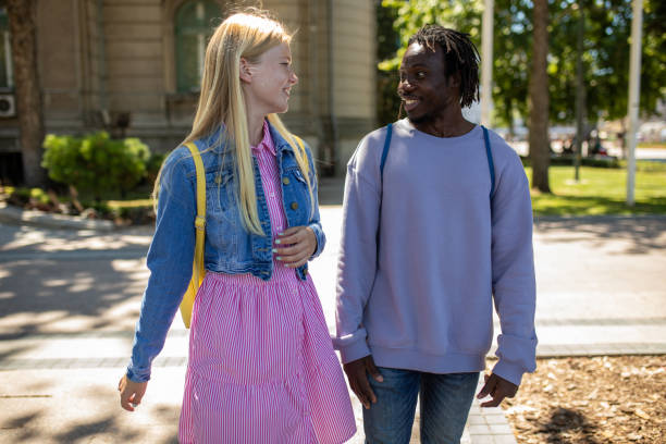 istock Multiracial friends talking and laughing while walking through city 1411416666