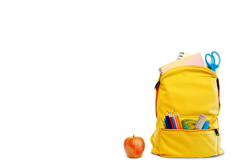 Backpack with different colorful stationery and apple on white background. Banner design back to school concept background. with the path
