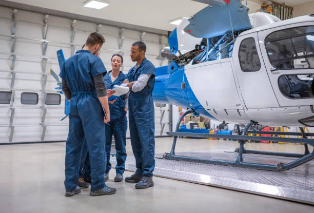 istock Group of mechanics discussing near helicopter 1411417433