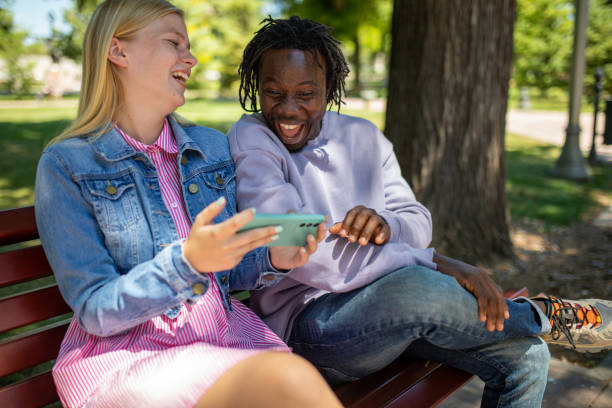 istock Multiracial friends watching funny content on the internet on mobile phone 1411417845