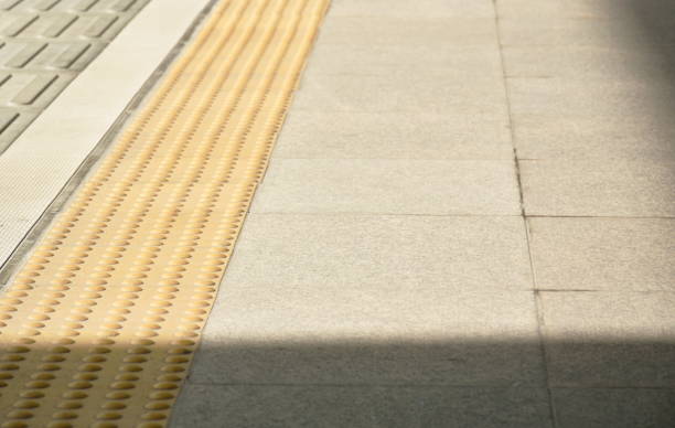 yellow security line in train station floor with shadow stock photo