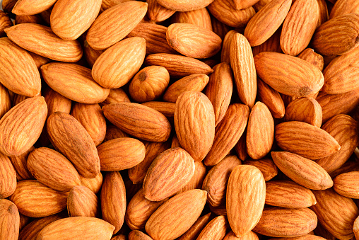 Bunch of fresh nuts of almonds on white background.
