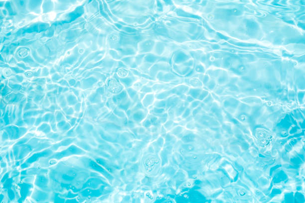 istock Blurred transparent blue colored clear calm water surface texture with splashes and bubbles. Trendy abstract nature background. Water waves in sunlight. water background 1411420525